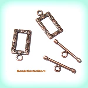 May include: Two copper-toned metal toggle clasps with ornate frames and two copper-toned metal T-bar clasps.