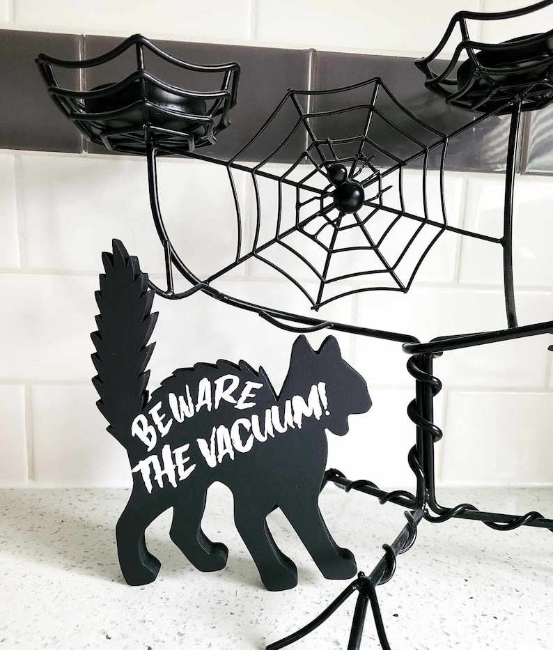 May include: Black metal spider web candle holder with a black cat silhouette that says "Beware the Vacuum!"
