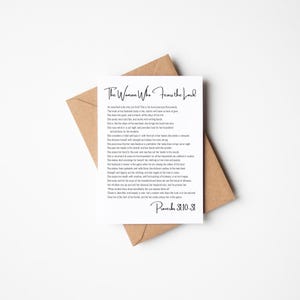 Puede incluir: Una tarjeta blanca con el texto "The Woman Who Fears the Lord" en una elegante escritura, junto con un pasaje de Proverbios 31:10-31. La tarjeta está colocada sobre un sobre marrón, creando una presentación simple y elegante.