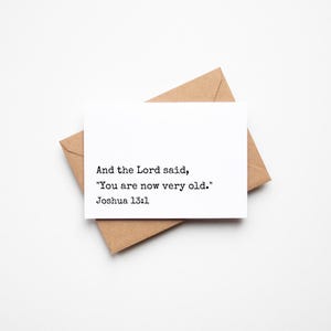 May include: A white greeting card with the text "And the Lord said, 'You are now very old.' Joshua 13:1" is placed on a brown envelope. The card and envelope are on a white background.