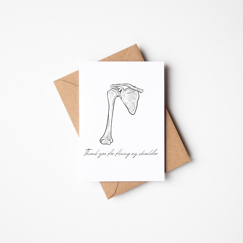 May include: A humorous greeting card with a black and white illustration of a human shoulder bone. The text on the card reads "Thank you for fixing my shoulder."