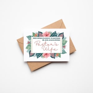 May include: A greeting card with the text "BEHIND EVERY PASTOR IS AN AMAZING Pastor's Wife" in a decorative frame. The card is surrounded by a floral design with pink flowers and green leaves. The card is placed on a brown envelope.