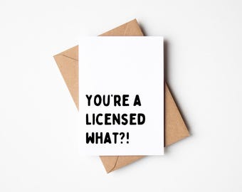 Puede incluir: Una tarjeta de felicitación blanca con el texto "YOU'RE A LICENSED WHAT?!" en negro, sobre un sobre marrón. La tarjeta y el sobre están sobre un fondo blanco. La tarjeta tiene una forma rectangular estándar.