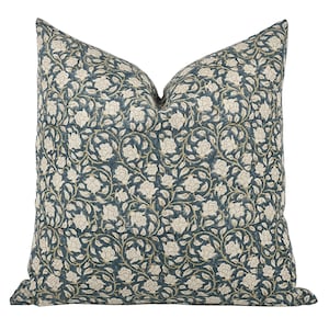 May include: A teal blue throw pillow with a white floral pattern. The pillow is made of a soft, comfortable fabric and features a subtle sheen.