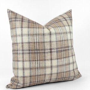 May include: A brown and white plaid throw pillow with a soft, textured fabric.