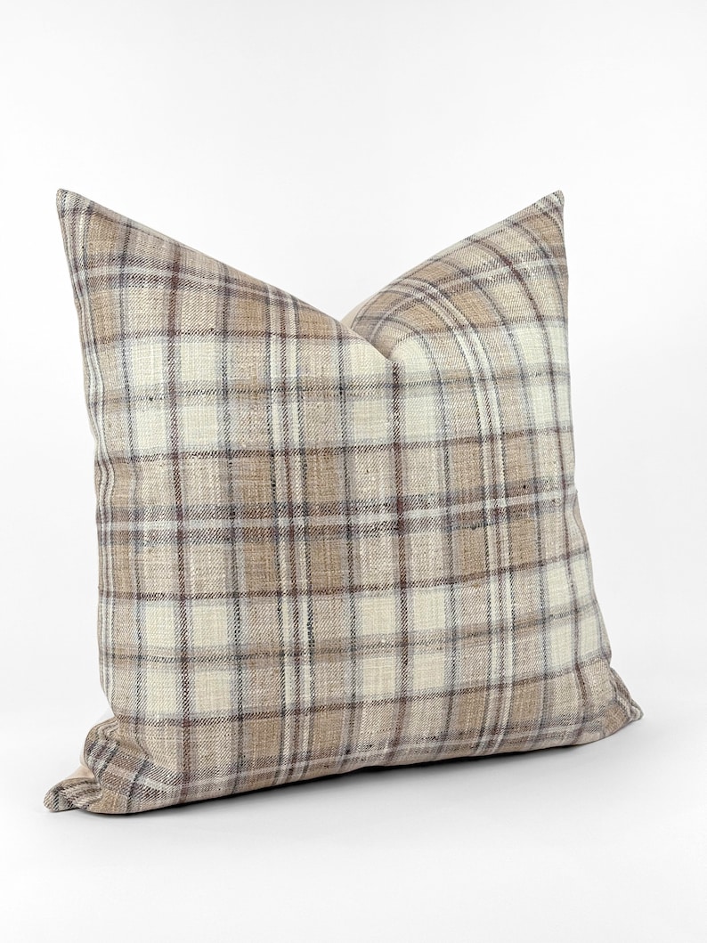 May include: A brown and white plaid throw pillow with a soft, textured fabric.