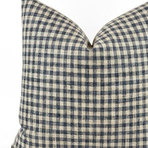 May include: A square throw pillow with a gingham pattern in shades of blue and cream.