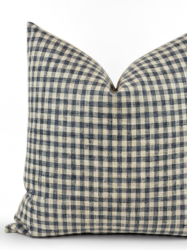 May include: A square throw pillow with a gingham pattern in shades of blue and cream.