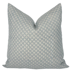 May include: A light blue cushion with a white floral pattern.