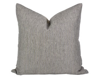 May include: A white pillow with black stripes. The pillow is made of a soft, textured fabric.