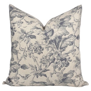 May include: A decorative throw pillow with a blue and white floral pattern. The pillow features a linen fabric with a subtle texture.