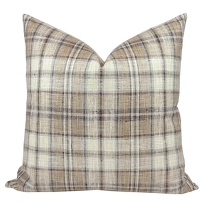 May include: A brown and white plaid throw pillow with a subtle sheen. The pillow is made of a soft, woven fabric.