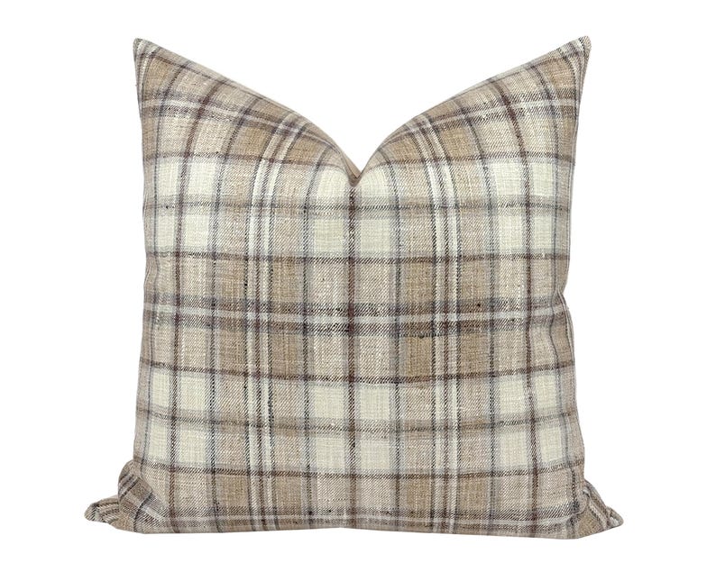 May include: A brown and white plaid throw pillow with a subtle sheen. The pillow is made of a soft, woven fabric.