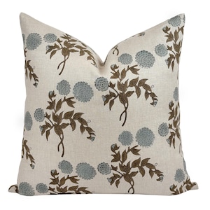 May include: A white linen pillow cover with a floral pattern. The flowers are blue and brown and have a vintage look.