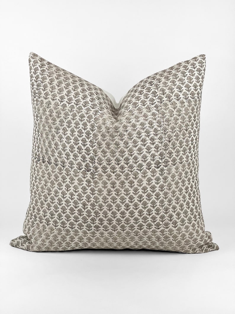 May include: A decorative throw pillow with a white background and a black floral pattern.