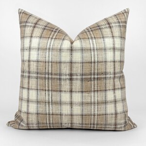May include: A brown and white plaid throw pillow with a square shape.