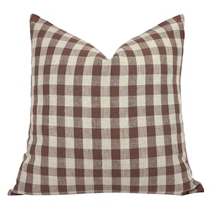 May include: A brown and white gingham pillow cover. The pillow cover is made of a soft, woven fabric and has a square pattern.