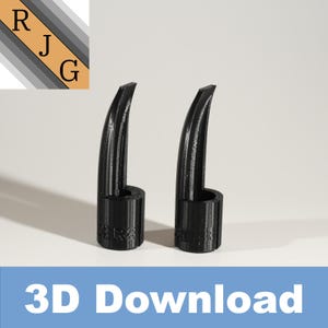 Pode incluir: Dois objetos pretos impressos em 3D com uma ponta pontiaguda e uma base cilíndrica. Os objetos estão sobre uma superfície branca.