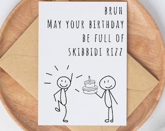 May include: A white card with black text and a simple line drawing of two stick figures. The text reads "Bruh May Your Birthday Be Full Of Skibbidi Rizz". One stick figure is holding a birthday cake with a single candle on top.