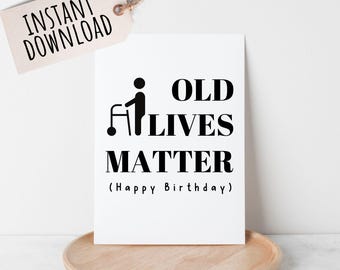 May include: A white card with black text that reads "Old Lives Matter (Happy Birthday)". A black silhouette of a person using a walker is to the left of the text.