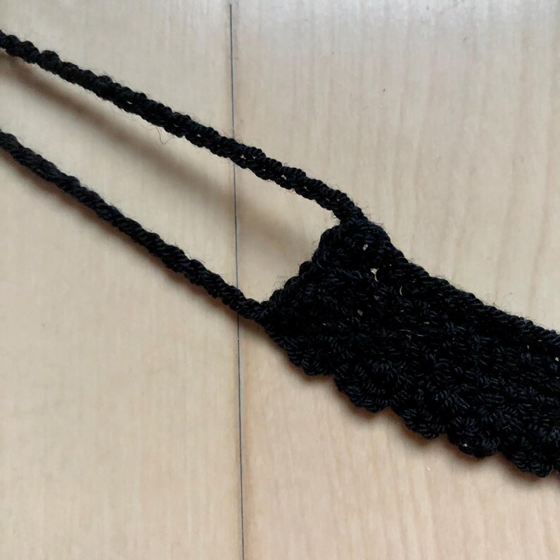 May include: Black crocheted cord with a black crocheted tassel at the end.