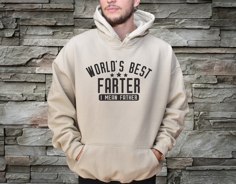 May include: A beige hoodie with a black graphic that says "World's Best Farter I Mean Father" with three stars.