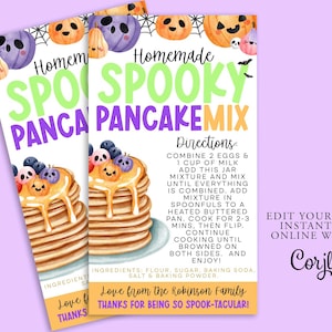 Könnte beinhalten: Druckbare Rezeptkarte für einen Halloween-Pfannkuchen-Mix mit einer Aquarell-Illustration eines Stapels Pfannkuchen, die mit gruseligen Gesichtern und einem Spinnennetz verziert sind. Die Karte trägt den Titel "Hausgemachter Grusel-Pfannkuchen-Mix" und enthält Anweisungen zum Zubereiten der Pfannkuchen. Die Karte enthält auch eine Nachricht von der Familie Robinson.