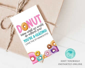 May include: A white card with pink and blue text that reads "DONUT know what we would do without you! YOU'RE A-GLAZING! LOVE THE ST MARK'S PTO". The card is decorated with colorful donut illustrations.