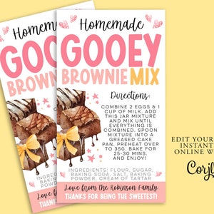 Può includere: Un biglietto di ricetta stampabile per un mix di brownie goloso. La carta presenta un'illustrazione ad acquerello di brownie con un nastro giallo. Il testo sulla carta recita "Mix di brownie goloso fatto in casa" e include le istruzioni per preparare i brownie. La carta include anche una nota della famiglia Robinson.