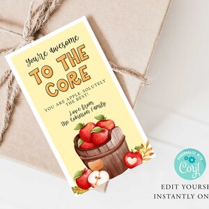 May include: A yellow card with the text "You're awesome to the core. You are apple-solutely the best! Love from the Robinson family."  The card features a watercolour illustration of a wooden bucket filled with red apples.