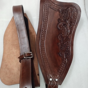 May include: A brown leather belt with a decorative floral design and a buckle. The belt is made of high-quality leather and is perfect for everyday wear.