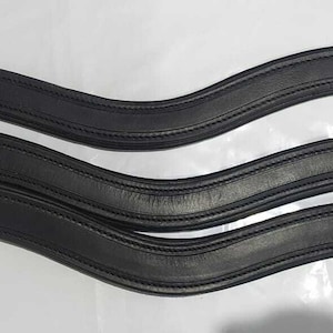 May include: Three black leather stirrup leathers with a curved shape.
