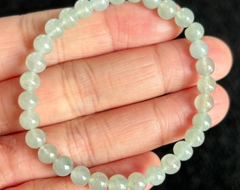 May include: A light green jade bracelet with round beads. The bracelet is made of natural jade and is approximately 7 inches in length.