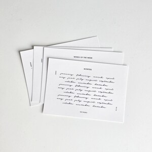 May include: A stack of white rectangular cards with black text. The top card features the heading MONTHS followed by a list of months in a cursive script font. Other visible text includes WEEKS OF THE WEEK, SCRIPT, HEADER 1, 1531 STUDIO, and 22-1A.