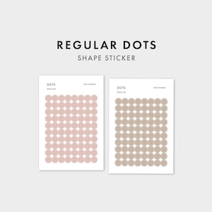 Może przedstawiać: Dwa prostokątne arkusze naklejek z napisem REGULAR DOTS SHAPE STICKER. Każdy arkusz zawiera siatkę okrągłych naklejek. Lewy arkusz zawiera jasnoróżowe kropki, a prawy arkusz beżowe kropki. Oba arkusze zawierają tekst DOTS, REGULAR oraz 1521 STUDIO.