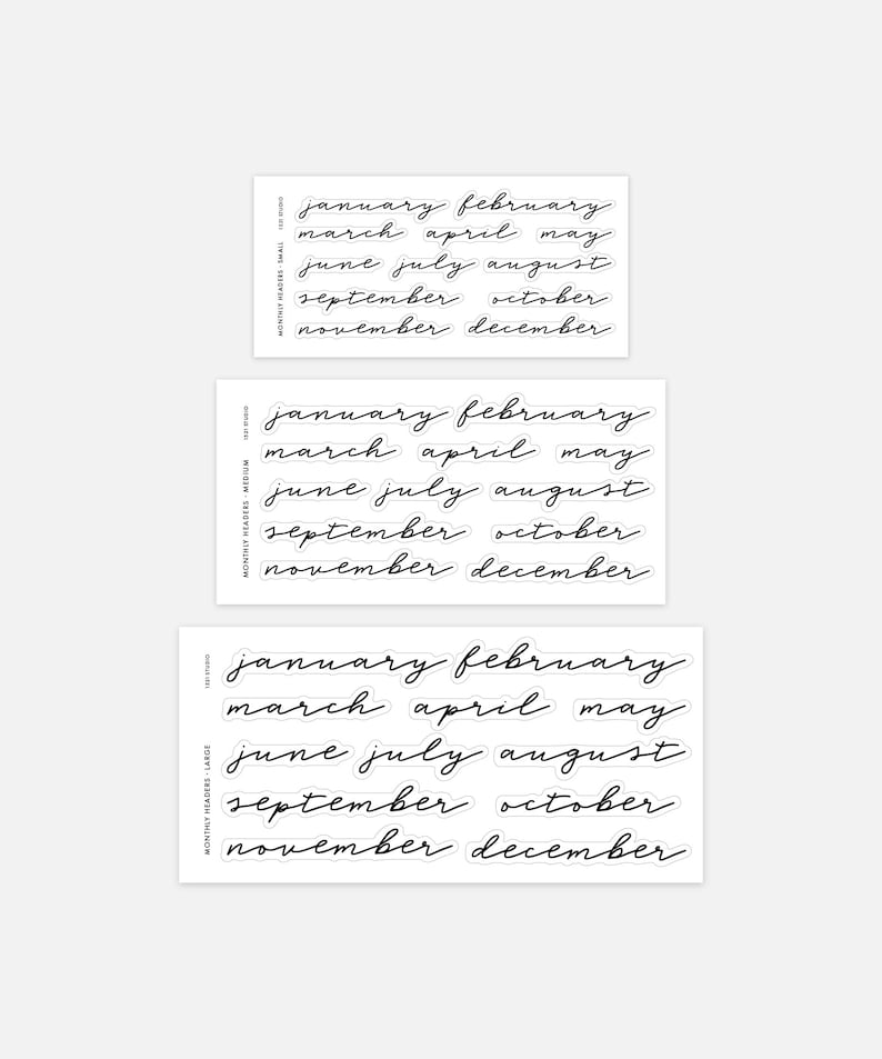 May include: Three sheets of black adhesive stickers featuring the months of the year in a cursive script font. Each sheet contains the months from January to December in small, medium, and large sizes, labelled as Monthly Headers.