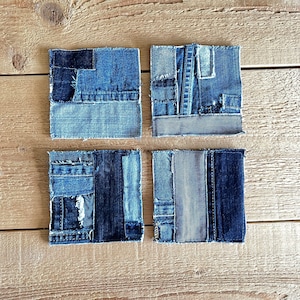 Può includere: Quattro sottobicchieri in denim blu con un design a patchwork. Ogni sottobicchiere è realizzato con diversi pezzi di denim cuciti insieme.
