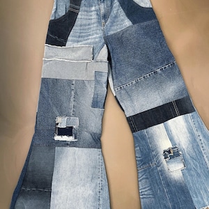 Könnte beinhalten: Weit geschnittene Jeans aus verschiedenen Blautönen von Denim-Stoff in einem Patchwork-Design. Die Hose verfügt über eine hoch taillierte Passform mit Knopfverschluss, mehrere rechteckige Denim-Einsätze, ausgefranste Kanten und Abnutzungen.
