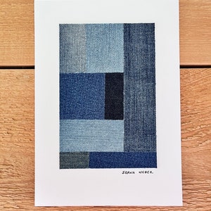 May include: Abstract art print featuring a geometric design made of different shades of blue denim fabric. The print is signed "JOANA WEBER" in the bottom right corner.