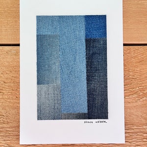 May include: Abstract art piece made of denim fabric in shades of blue. The artist's signature, "Ioana Weber", is written in black ink at the bottom of the piece.