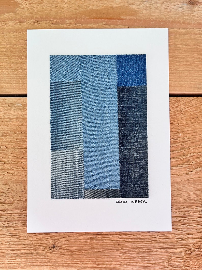 May include: Abstract art piece made of denim fabric in shades of blue. The artist's signature, "Ioana Weber", is written in black ink at the bottom of the piece.