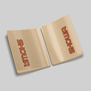 May include: Two beige stickers with the word "SHOWA" printed in orange letters. The stickers are slightly curved and have a glossy finish.