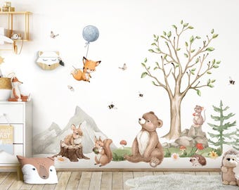 Op de afbeelding: Een set met dierlijke wanddecoraties in aquarelstijl met een vos met een ballon, een beer, een eekhoorn, een konijn, een muis, een egel en een dennenboom. De stickers zijn perfect voor een kinderkamer of babykamer.