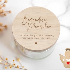May include: A wooden lid with the text "Besondere Menschen sind die, die gar nicht wissen, wie wundervoll sie sind" and a small heart symbol. The lid is on top of a glass jar.