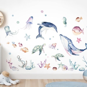 Op de afbeelding: Een set kleurrijke wanddecoraties met een oceaan thema, met een walvis, dolfijnen, kwallen, zeeschildpadden, zeesterren en vissen. De stickers zijn perfect om een kinderkamer of een babykamer een speelse touch te geven.
