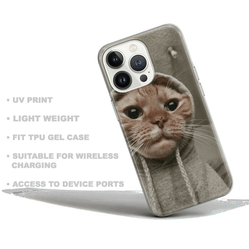 May include: A clear phone case with a printed image of a cat wearing a gray hoodie. The case is designed for a phone with a triple camera system.