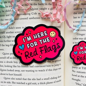 Peut inclure: Deux autocollants roses et rouges en forme de nuage avec des étoiles blanches. Le texte sur les autocollants est "Je suis là pour les drapeaux rouges". Les autocollants ont un visage souriant et un cœur.