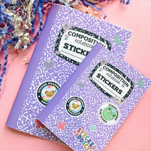 Puede incluir: Dos cuadernos de composición con una cubierta lila y motas blancas. Los cuadernos tienen pegatinas que dicen "Sticker Hoarder" y "Sticker Addict". Los cuadernos tienen las palabras "Composition Notebook Stickers" en la portada.