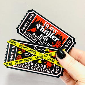 Op de afbeelding: Twee zwarte en rode tickets met de tekst "In my thriller era" en "Book Club Lifetime Membership". E&eacute;n ticket is gekruist met gele tape met de tekst "Scene - Do Not Cross" en "Crime Scene".