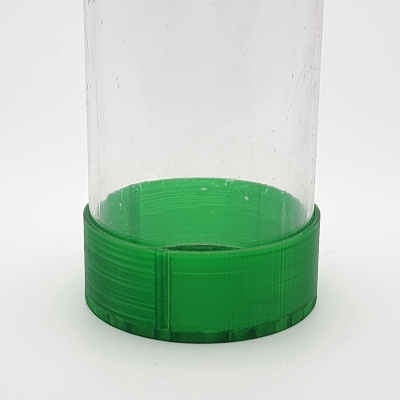 May include: A clear glass jar with a green plastic lid. The lid has a textured surface.